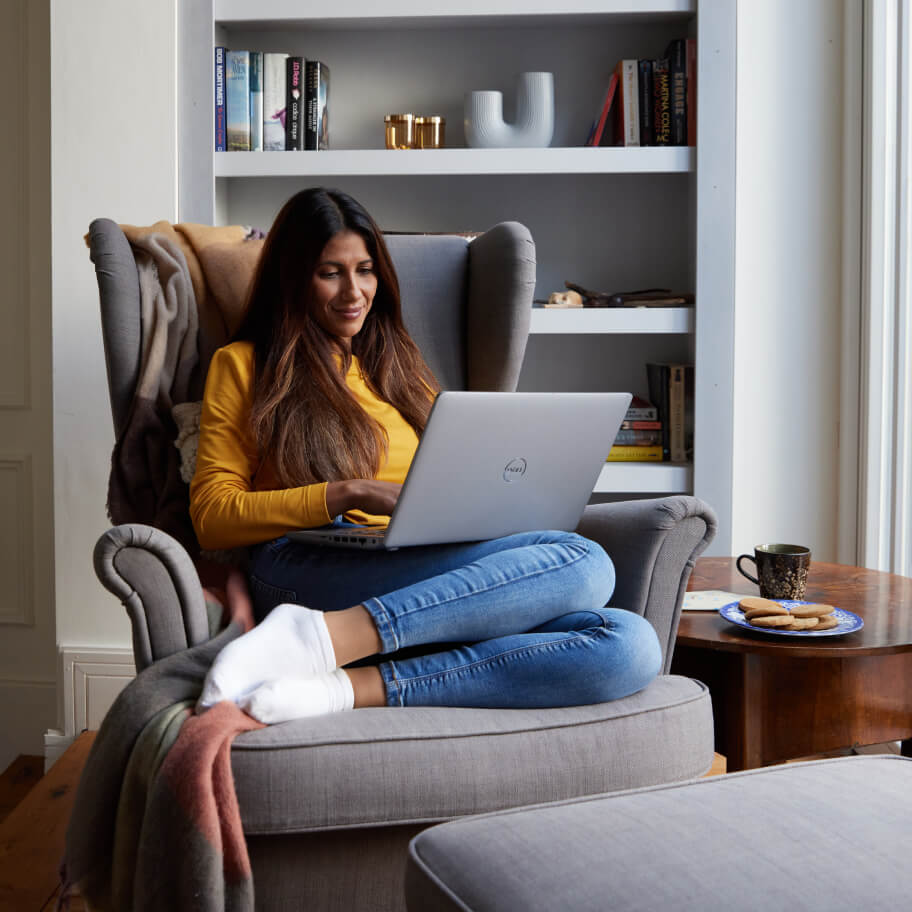 Man with his daughter on a couch showing her an electronic tablet