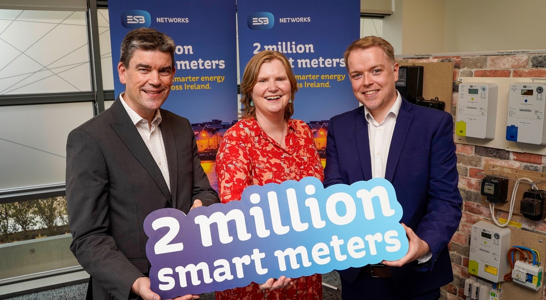 Image of three people holding a banner to celebrate 2 million smart meter installs