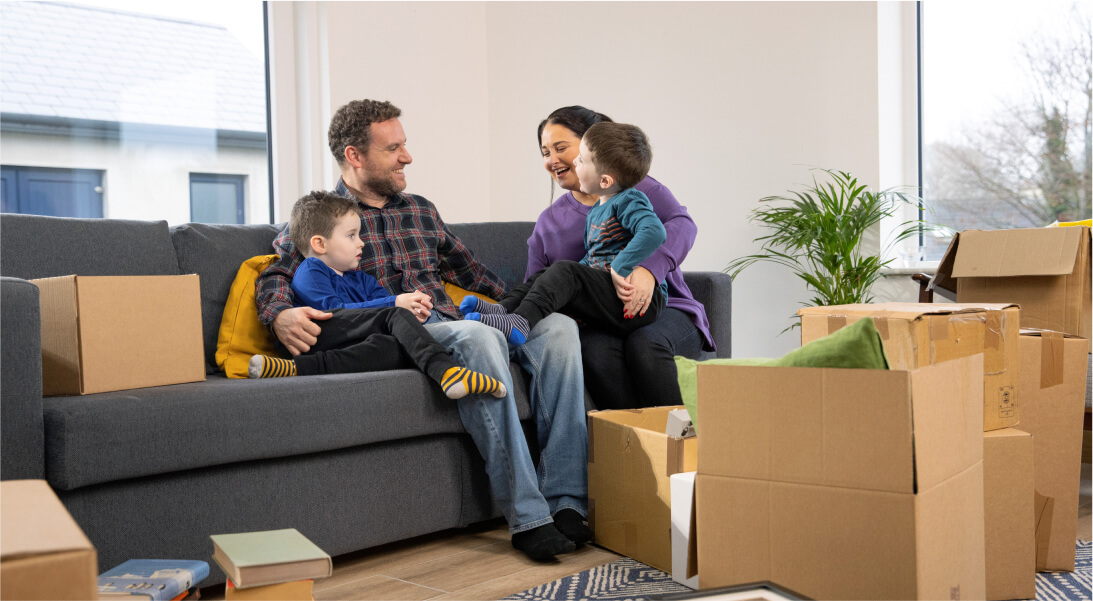 Family relaxing after moving in surrounded by boxes