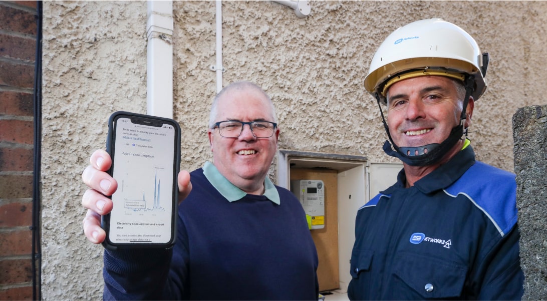 ESB Networks technician with a customer showing a smartphone screen