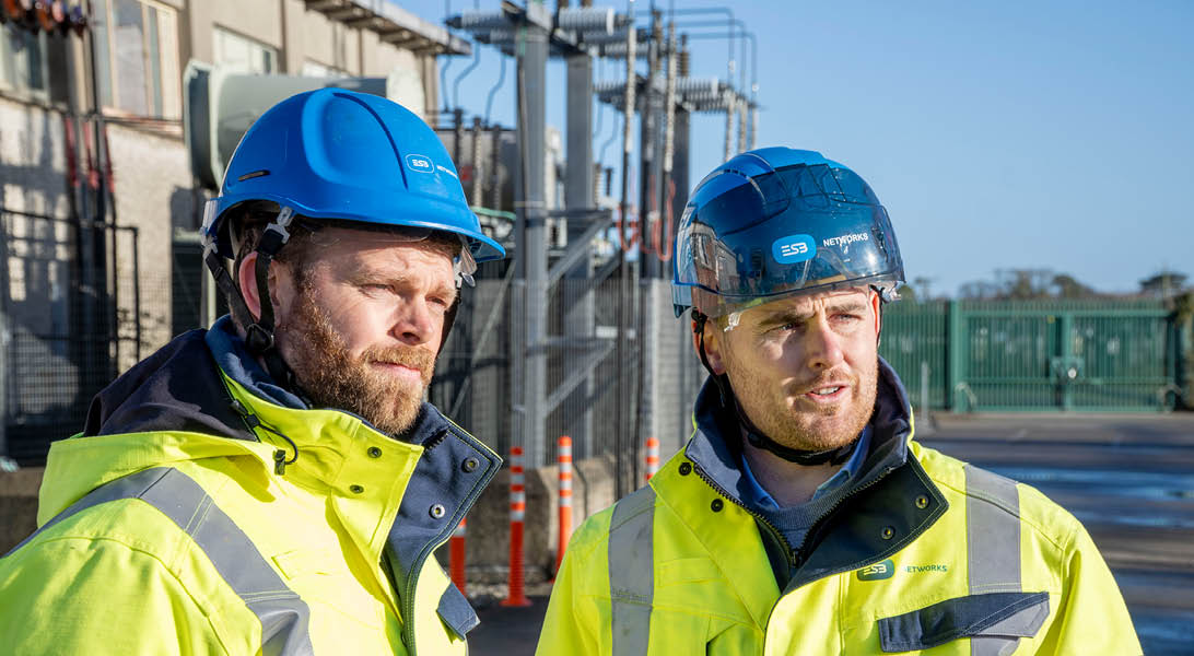 Image of two people beside a substation