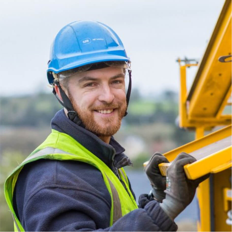 Technician smiling, with his hands on his truck